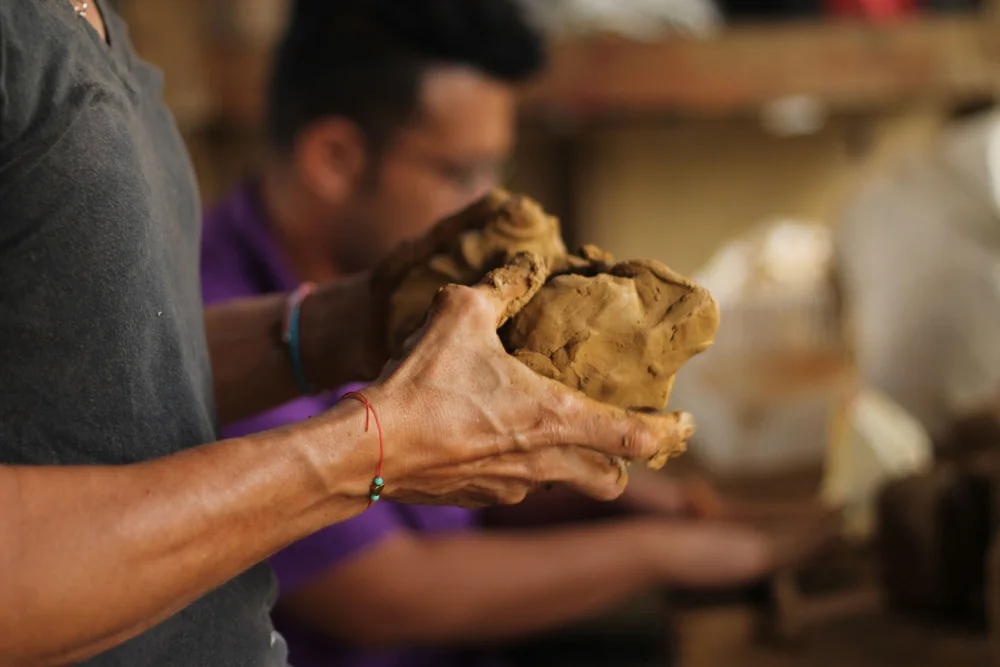 Hands shaping clay during the original pottery experience